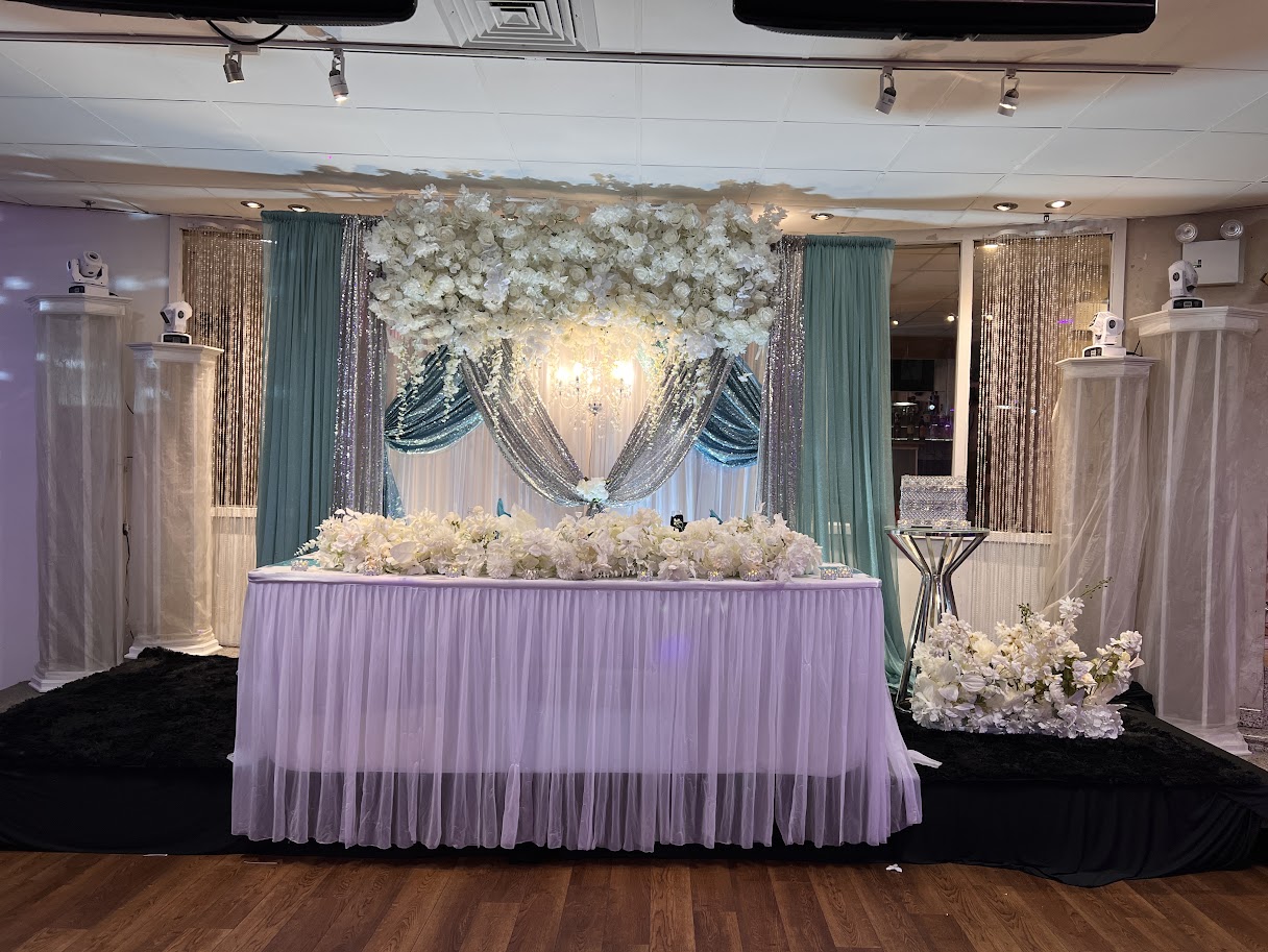 Head table draping with warm ambient lighting and delicate floral touches.
