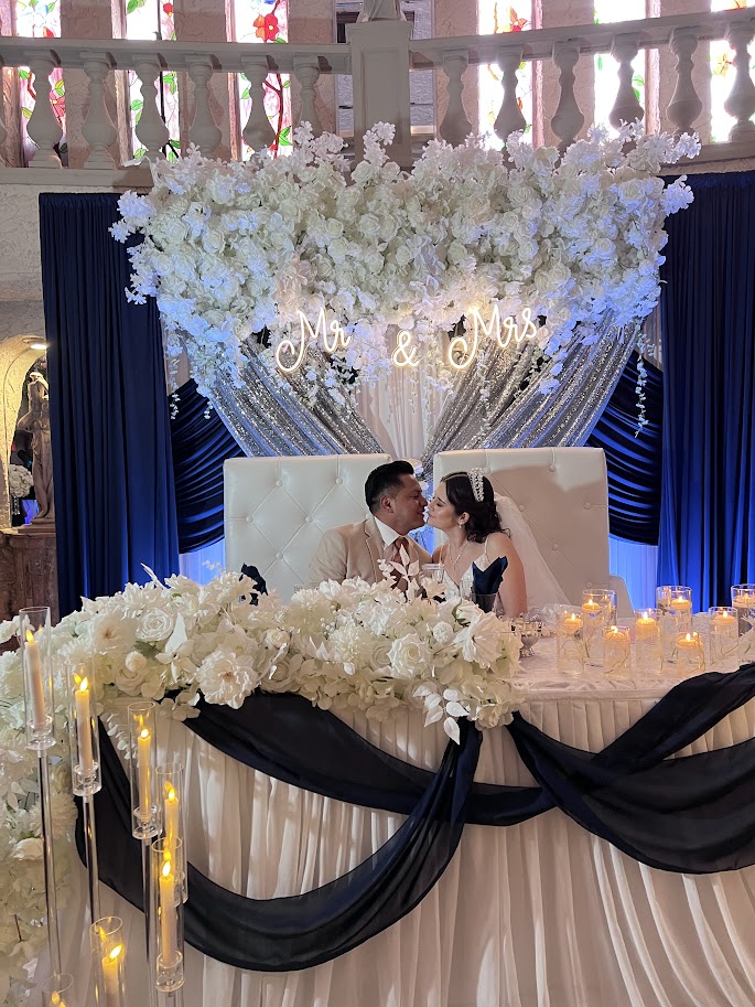 Head table draping with warm ambient lighting and delicate floral touches.